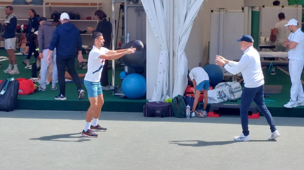 Novak se zagreva za meč – neočekivan susret FOTO