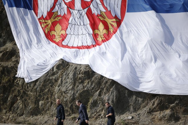 Vucic (center) flanked by his bodyguards,walks under a giant Serbian flag during his visit to the Gazivode Dam on Saturday (Tanjug/AP)