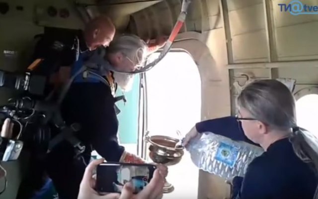 Protiv bluda i alkohola: Ruski sveštenici svetom vodicom iz aviona osveštali grad VIDEO