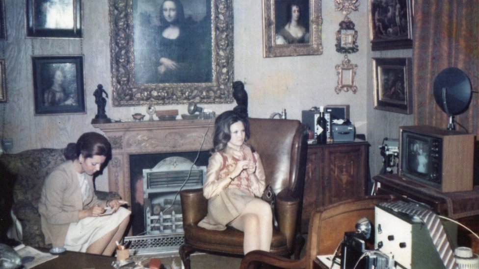 Dve žene sede ispod slike Mona Lize/Gilbert family