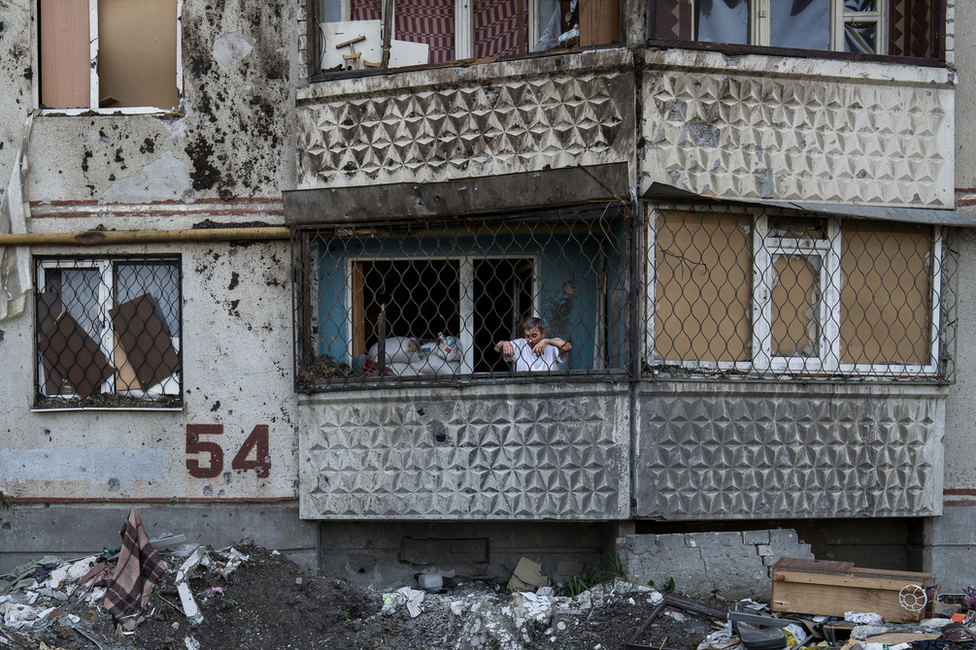 Stanovnik zgrade broj 54 u Saltivki gleda sa balkona krater od granate ispod sebe. &Ovo je ruski svet&, kaže on/BBC