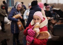 Desetogodišnja Anatasija drži vekne hleba koje joj je dao volonter, Herson/Reuters