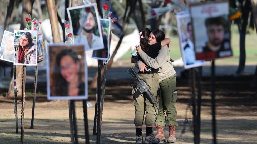 Pripadnice izraelske vojske okružene slikama žrtava sa festivala Supernova, koje je Hamas napao 7. oktobra/EPA