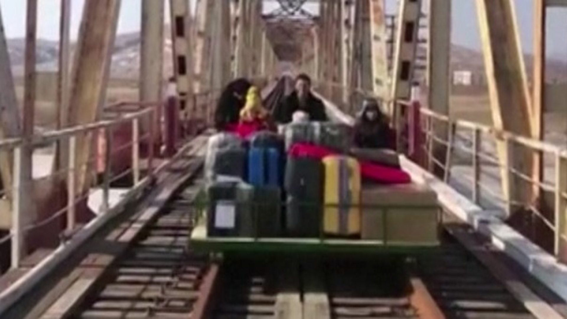 Russians cheer as they exit North Korea on hand-pushed trolley